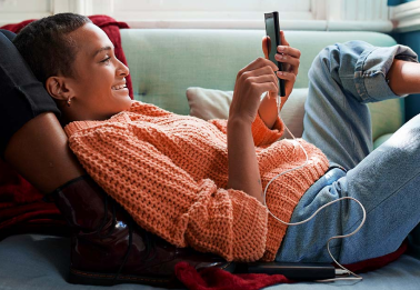 Vrouw op de bank met mobieltje in haar hand