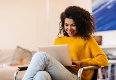 Lachende vrouw kijkt op laptop